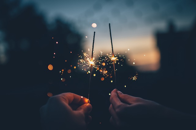 Hands holding sparklers in the dark